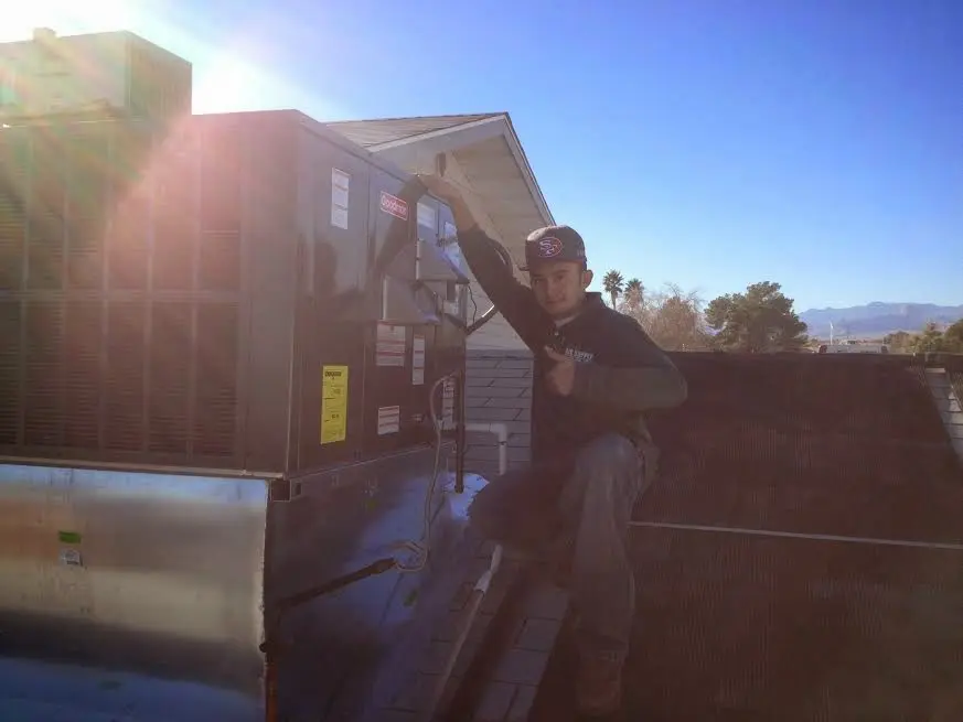 HVAC technician performing AC Tune-Up on a rooftop unit in Spout Springs